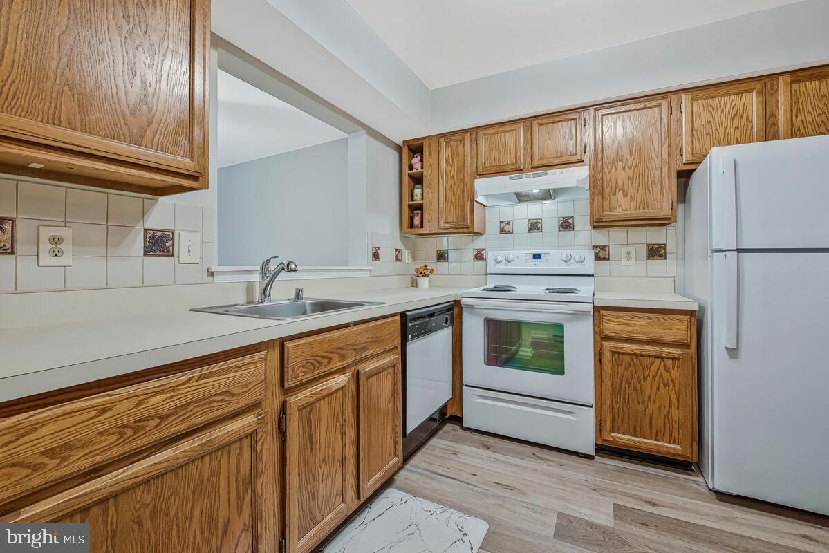 20334 Beaconfield Terrace, Unit 2 Germantown, MD 20874 - Photo 10 of 24 a kitchen with stainless steel appliances granite countertop a sink stove and refrigerator