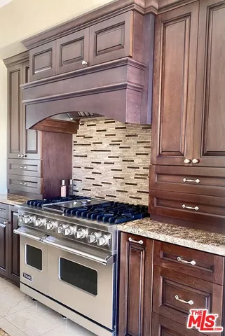 a kitchen with stainless steel appliances granite countertop a sink stove and cabinets