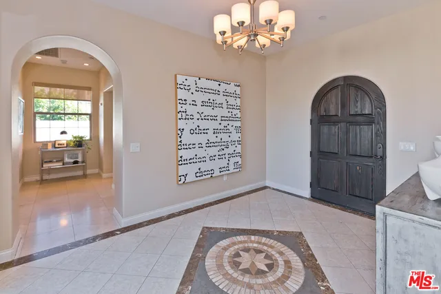 a spacious bedroom with a bed a mirror and a large window