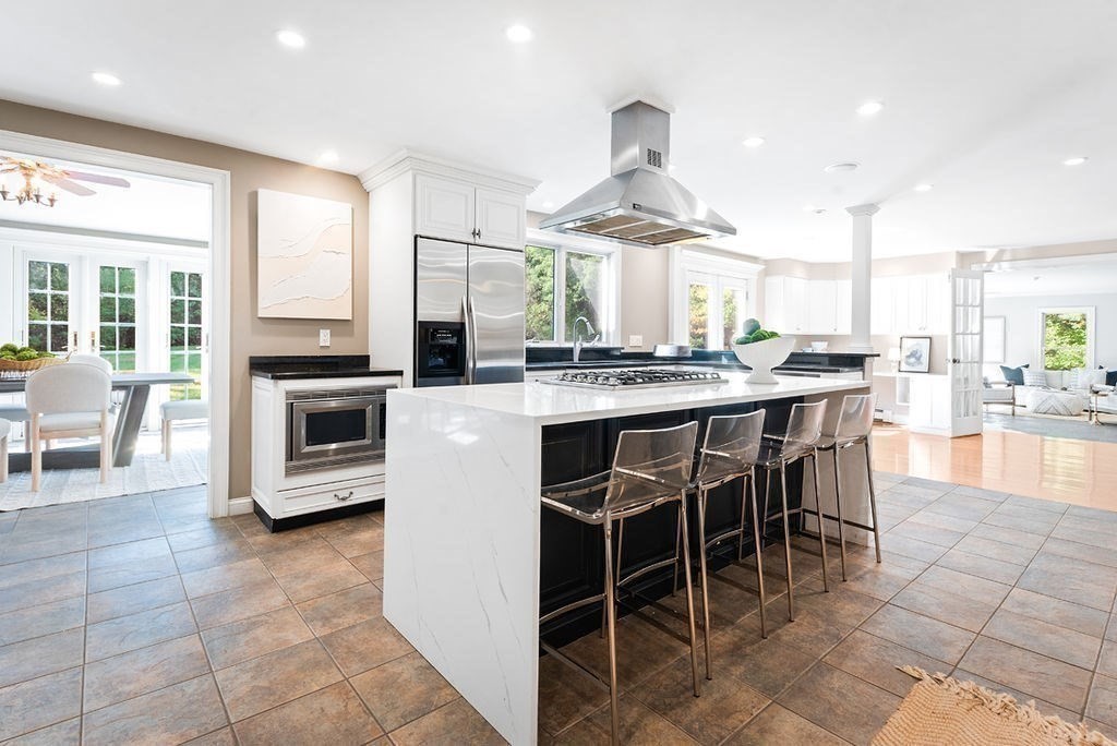 a kitchen with stainless steel appliances a stove a sink a oven a dining table and chairs