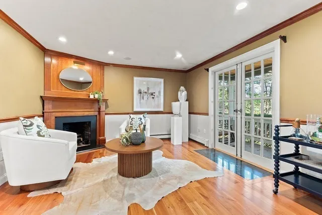 a living room with furniture a fireplace and a floor to ceiling window