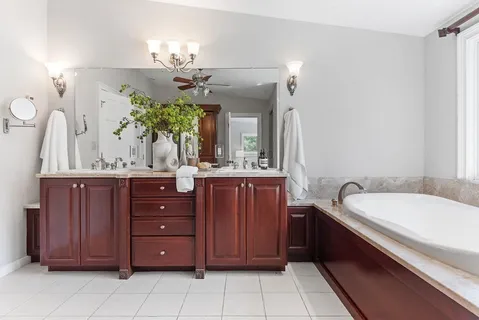 a spacious bathroom with a granite countertop sink a mirror and a bathtub