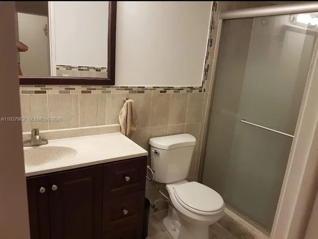 a bathroom with a toilet a sink and mirror