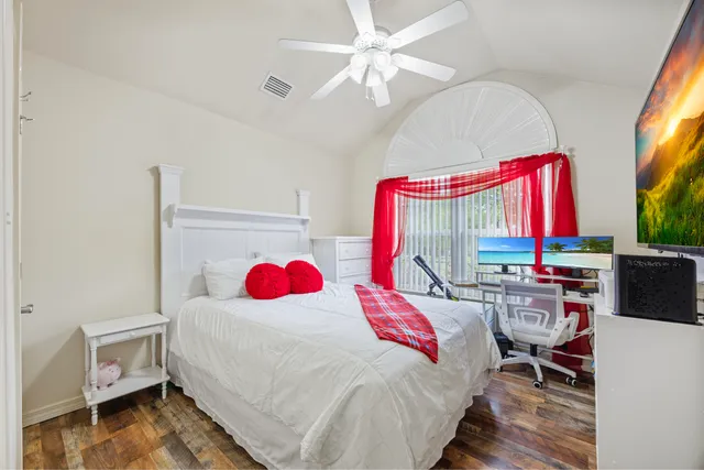 a bedroom with a bed dresser and a large window