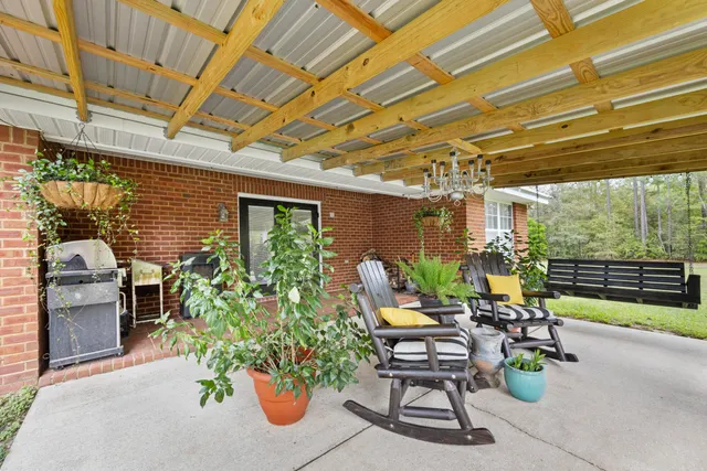 a patio with table and chairs and potted plants