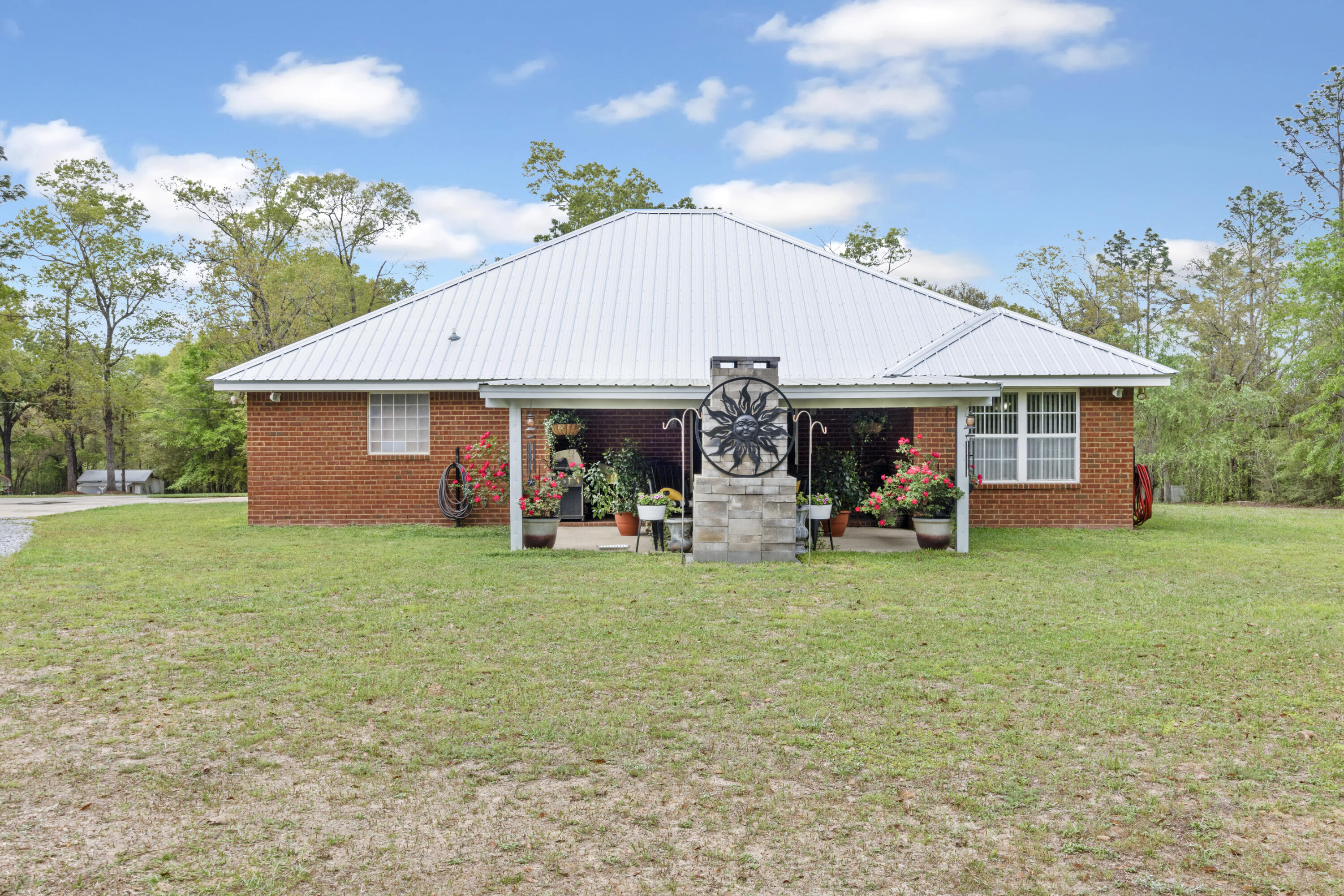 1582 Greenwood Road Baker, FL 32531 - Photo 30 of 52 a view of a house with a patio and a garden