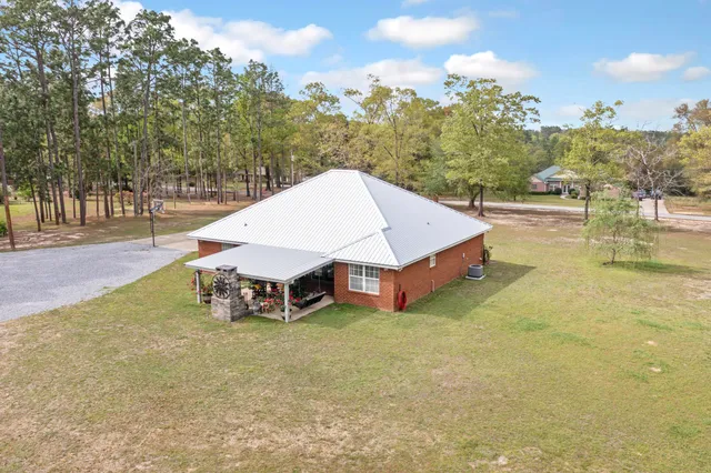 a view of a house with backyard and trees