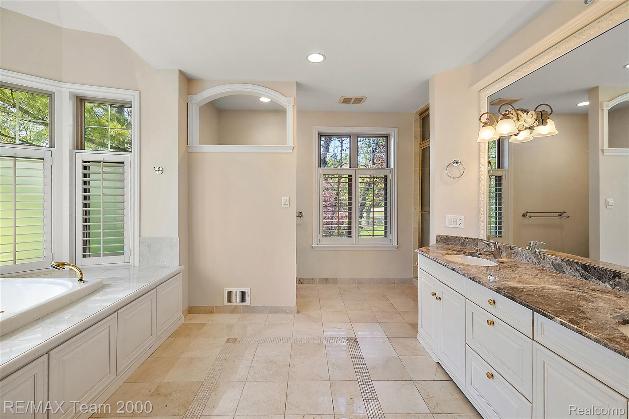 630 Sheldon Court Rochester, MI 48306 - Photo 44 of 94 Bathroom featuring a bath, double vanity, inlaid floor details, recessed lighting, and light tile patterned flooring