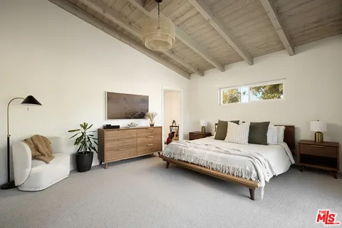 a bedroom with a bed and flat screen tv