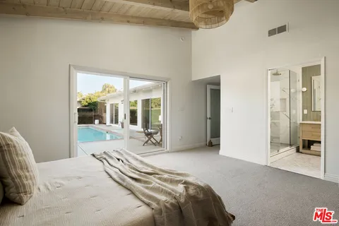 a bedroom with a bed and a large window