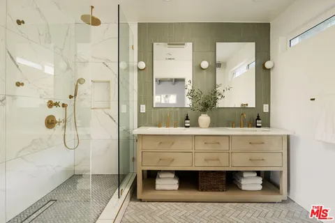a bathroom with a double vanity sink mirror and shower