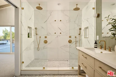 a bathroom with a double vanity sink mirror and shower