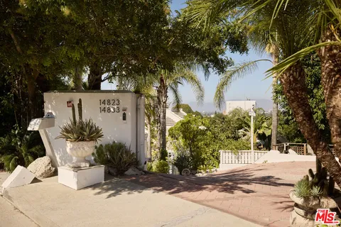 a front view of a house with a tree