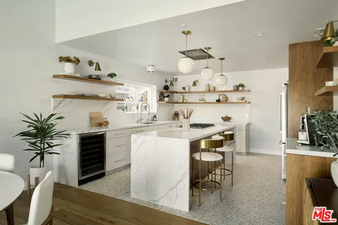 a kitchen with granite countertop a table chairs stove and cabinets