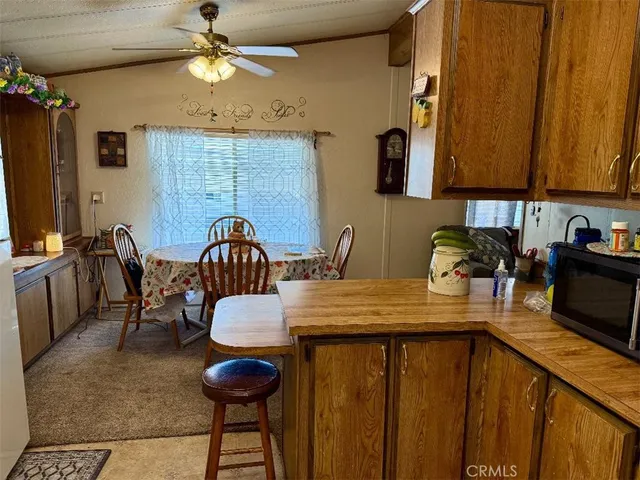 a kitchen with stainless steel appliances a table chairs and a refrigerator