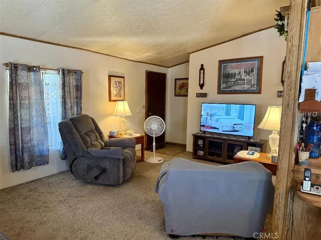 a living room with furniture a window and a flat screen tv