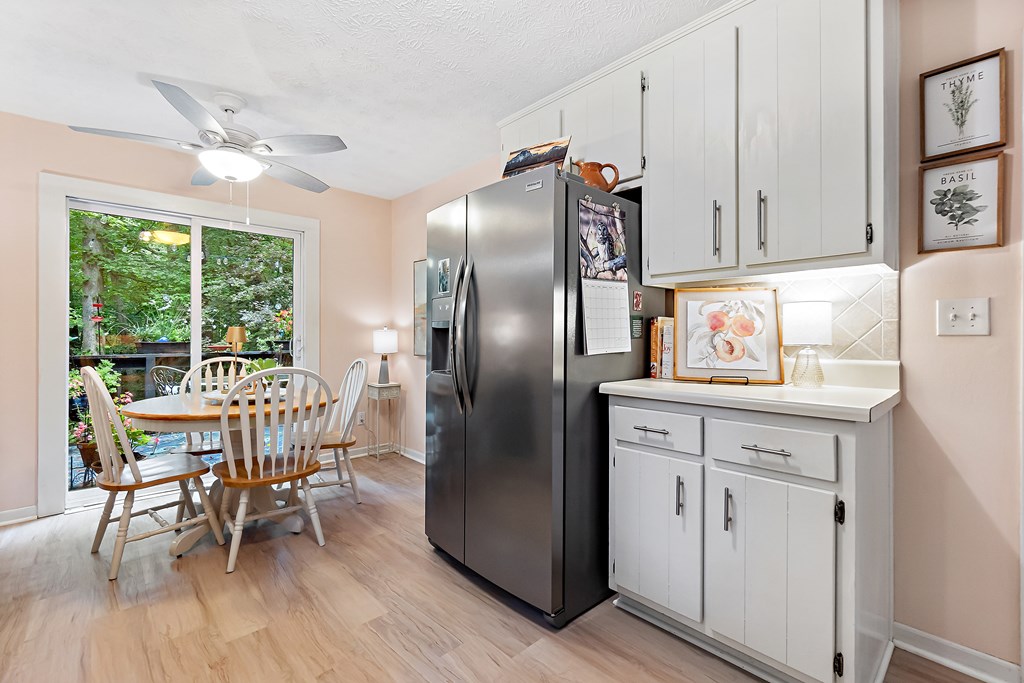 706 Magnolia Way Woodstock, GA 30188 - Photo 12 of 24 a kitchen with stainless steel appliances granite countertop a refrigerator a stove a dining table and chairs with wooden floor