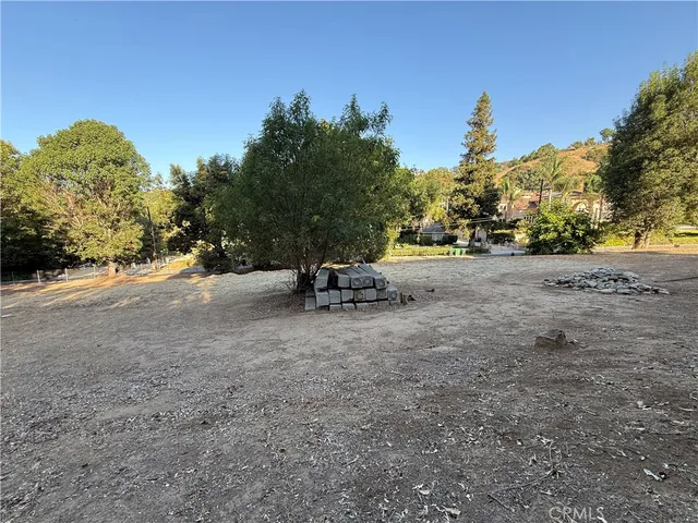a view of a dirt road with trees in the background