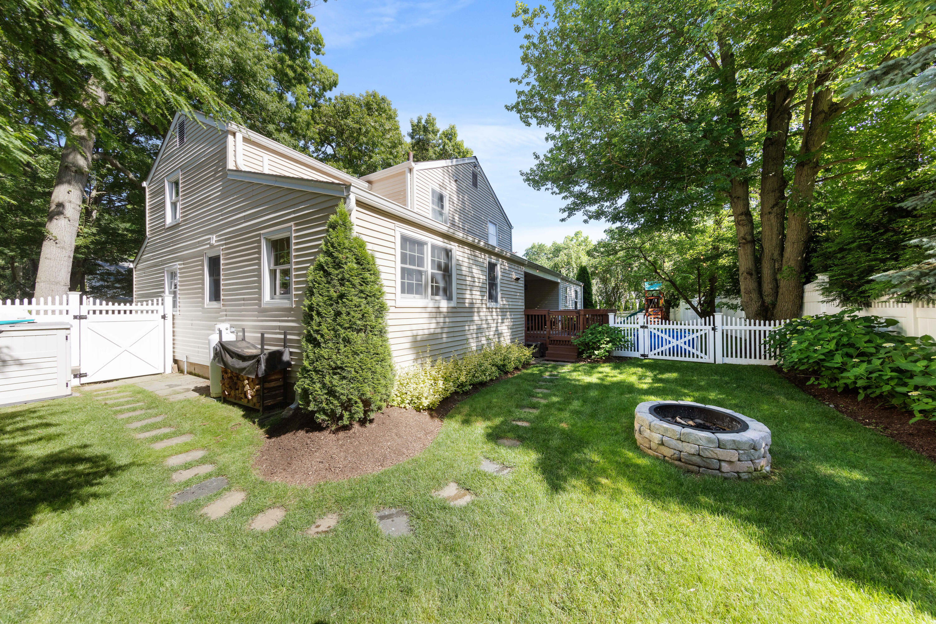 12 Miles Road Darien, CT 06820 - Photo 26 of 31 a view of a backyard with table and chairs potted plants and large tree