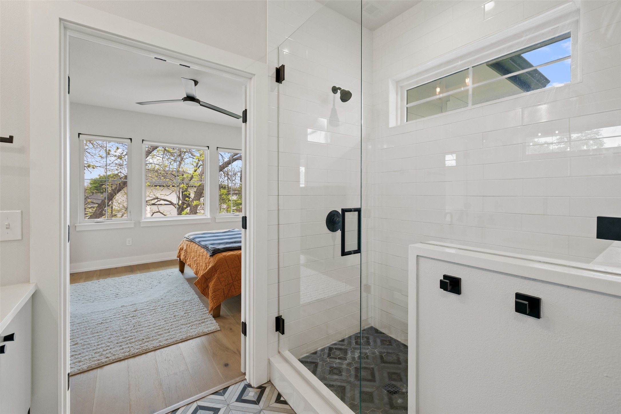 1504 Ruth Avenue, Unit 3 Austin, TX 78757 - Photo 21 of 39 A well-lit bedroom with light wood flooring transitions to a modern bathroom with a glass-enclosed shower.