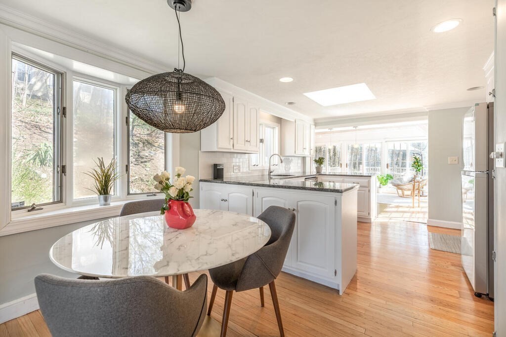 382 Worcester Street Wellesley, MA 02481 - Photo 5 of 22 a kitchen with granite countertop a dining table chairs and white cabinets