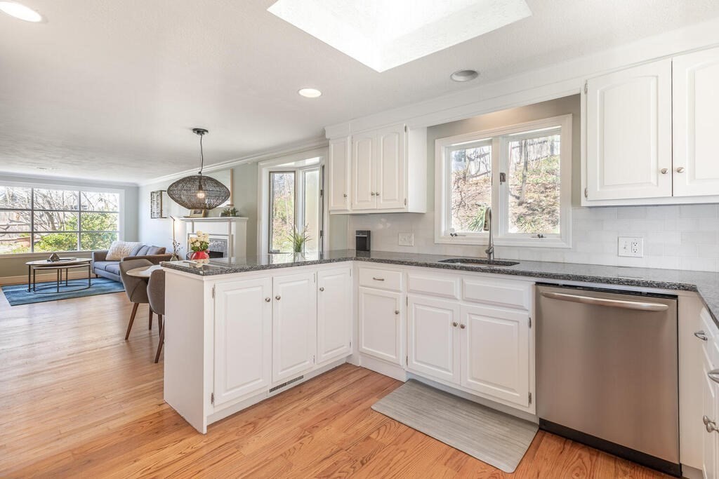 382 Worcester Street Wellesley, MA 02481 - Photo 7 of 22 a kitchen with kitchen island granite countertop white cabinets and white appliances