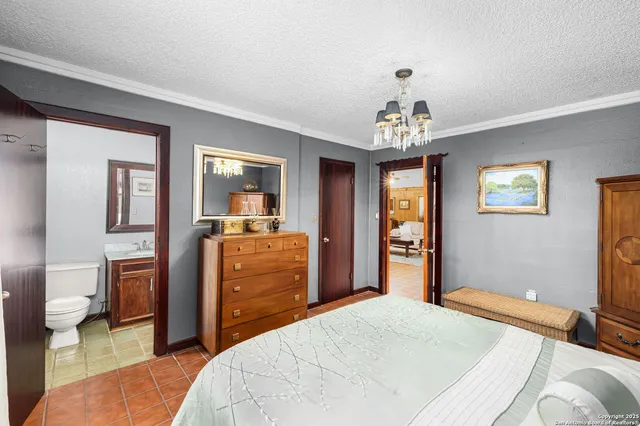 a bedroom with a bed and a chandelier