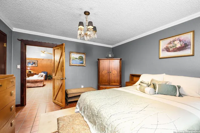 a bedroom with a large bed and a chandelier