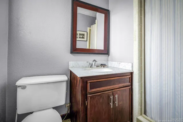 a bathroom with a toilet sink and mirror