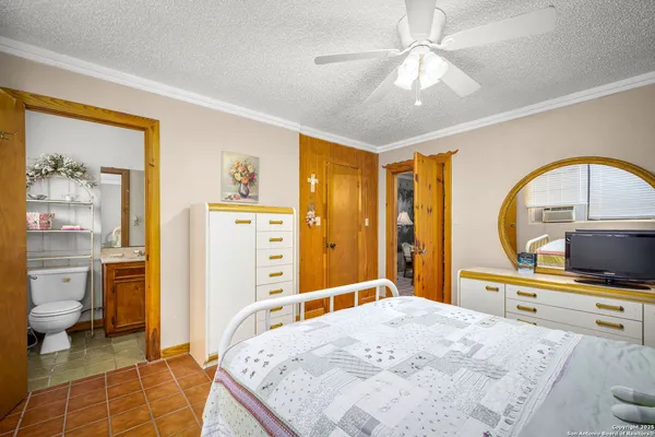 a bedroom with a bed a flat screen tv and balcony view