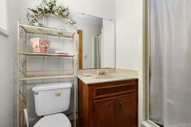 a bathroom with a toilet a sink and a mirror