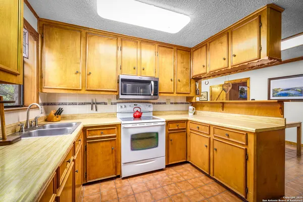 a kitchen with stainless steel appliances granite countertop a sink a stove and a refrigerator