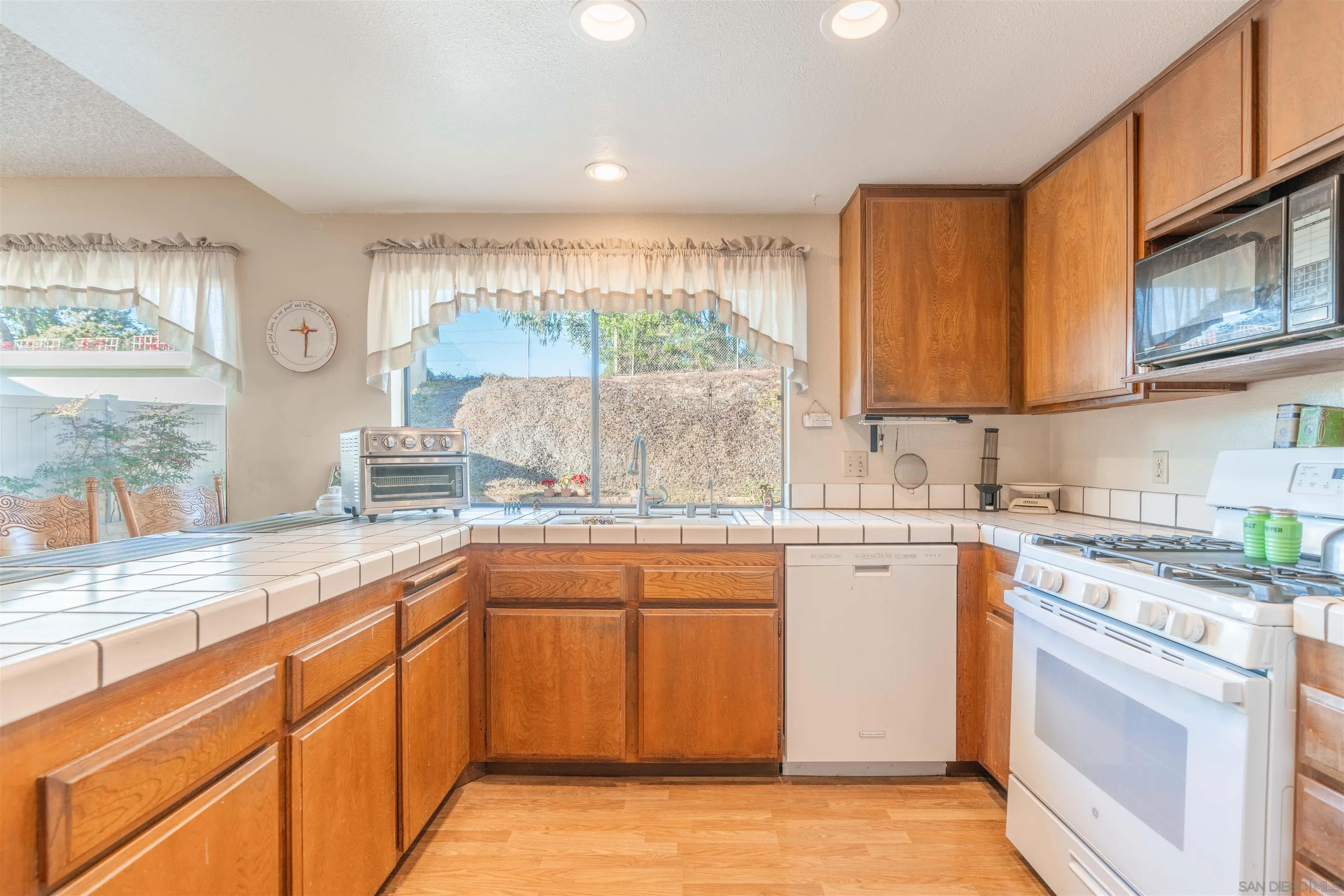 1440 Valleda Lane Encinitas, CA 92024 - Photo 16 of 54 a kitchen with stainless steel appliances granite countertop a stove a sink and a microwave
