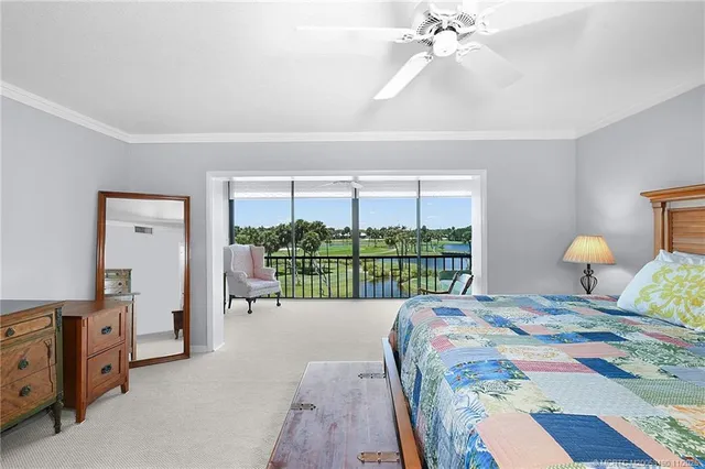 a bedroom with a bed mirror on desk and a window