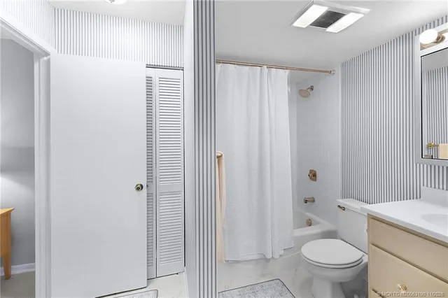 a bathroom with a sink vanity mirror and toilet
