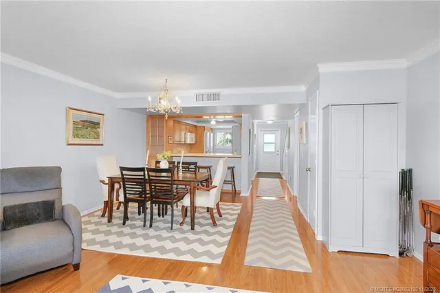 a view of a dining room with furniture a chandelier and wooden floor