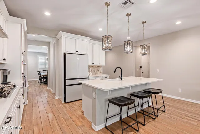 a kitchen with white cabinets and stainless steel appliances