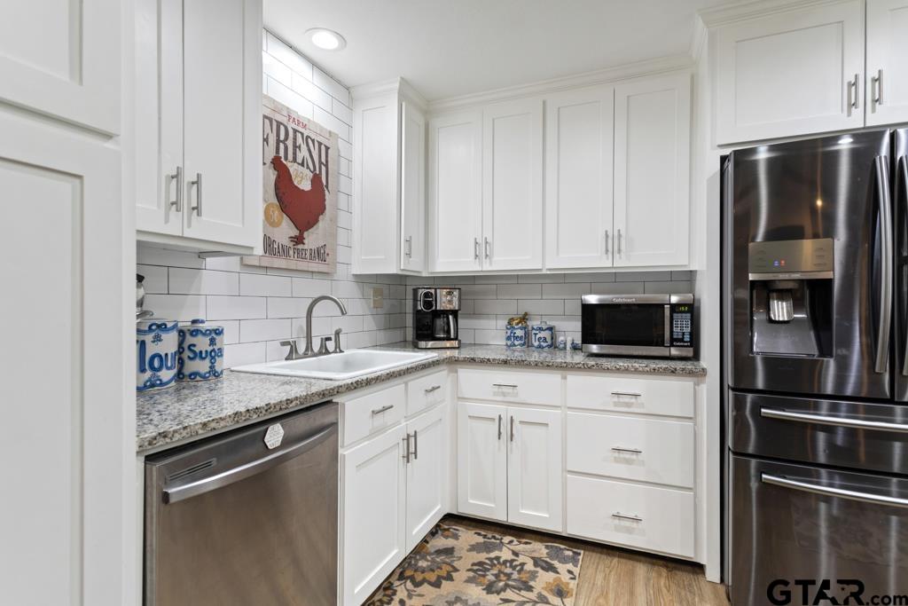 106 Ridgecrest Circle Bullard, TX 75757 - Photo 14 of 32 a kitchen with stainless steel appliances granite countertop a refrigerator and sink