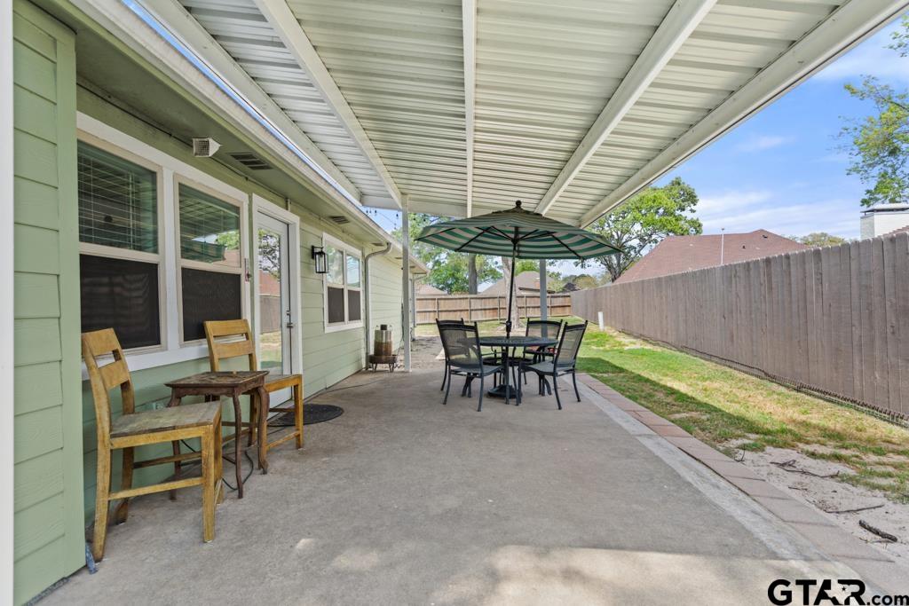 106 Ridgecrest Circle Bullard, TX 75757 - Photo 4 of 32 a view of a patio with table and chairs under an umbrella with a small yard