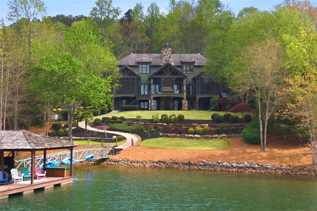 This exquisite waterfront retreat features a beautifully landscaped yard, private dock, and screened porches.