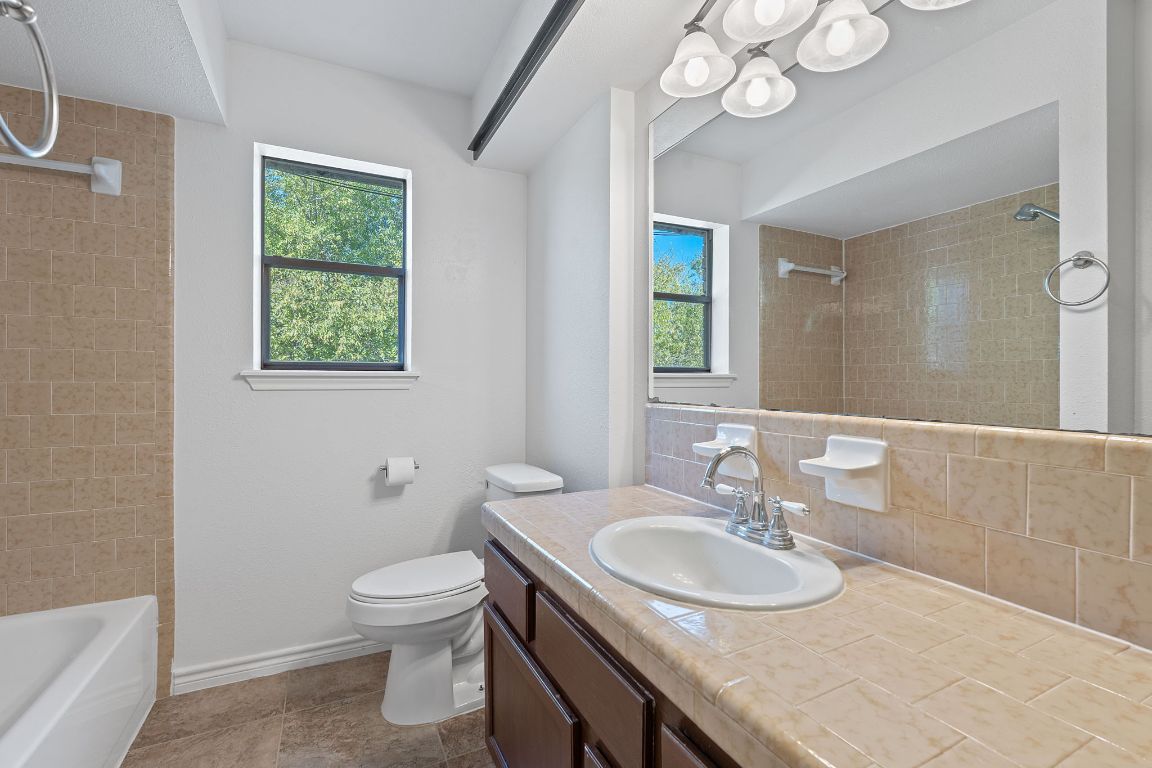 130 Meyers Road Buda, TX 78610 - Photo 17 of 35 a bathroom with a granite countertop toilet a sink and a mirror