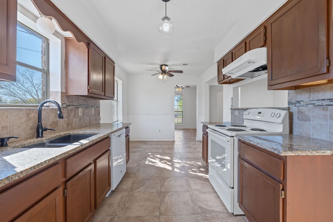 130 Meyers Road Buda, TX 78610 - Photo 5 of 35 a kitchen with stainless steel appliances granite countertop a sink stove and refrigerator