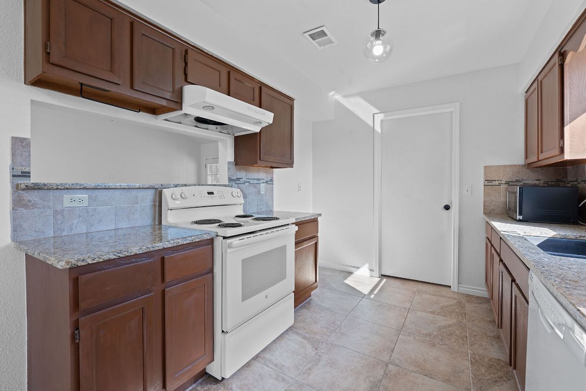 130 Meyers Road Buda, TX 78610 - Photo 9 of 35 a kitchen with a stove and a microwave