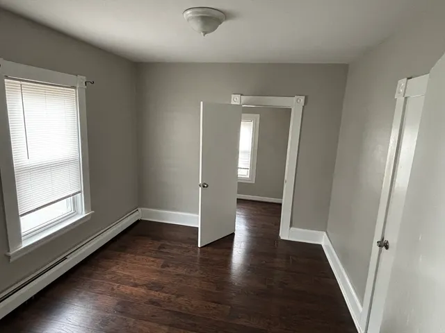 a kitchen with white cabinets appliances a sink and a window