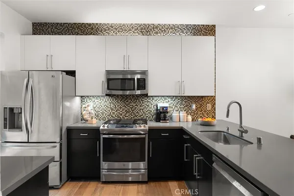 a kitchen with appliances a sink and cabinets