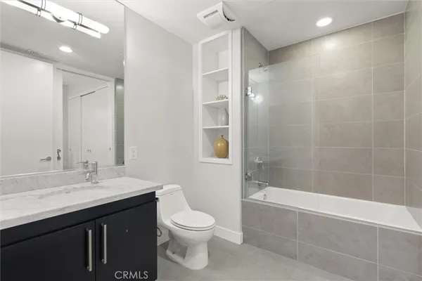 a bathroom with a bathtub shower sink vanity and toilet