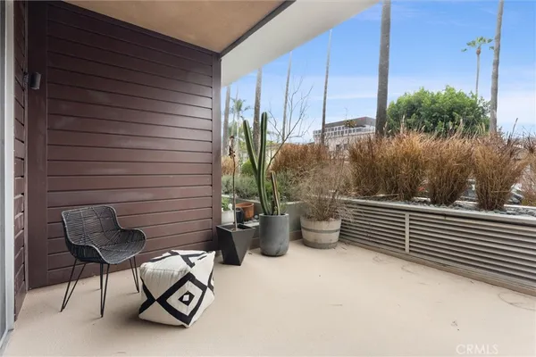 a view of a patio with chairs and potted plants