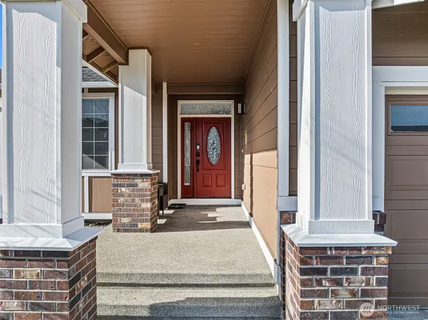 a view of a hallway with a front door and windows