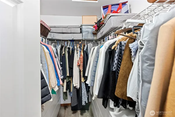 a view of walk in closet with clothes and shoes