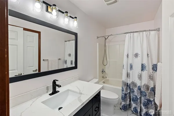a bathroom with a sink a toilet and a mirror